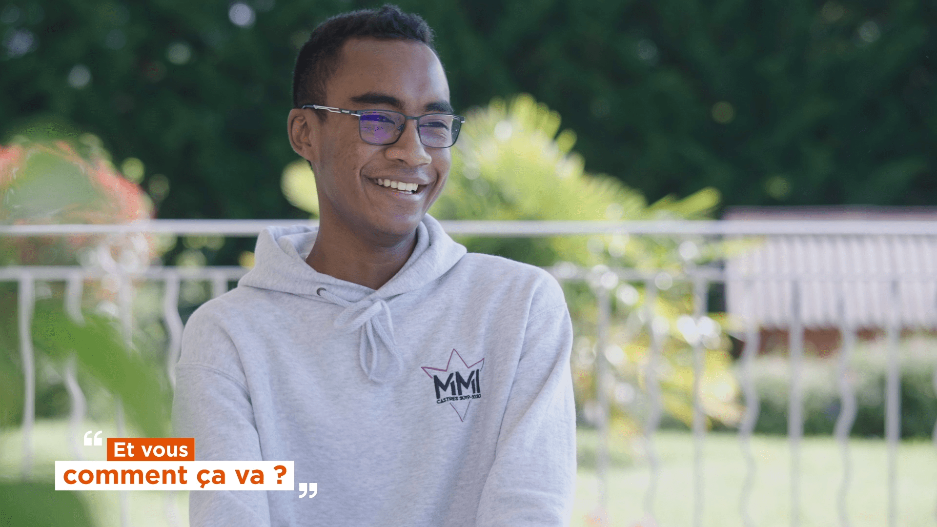 garçon souriant avec un sweat gris